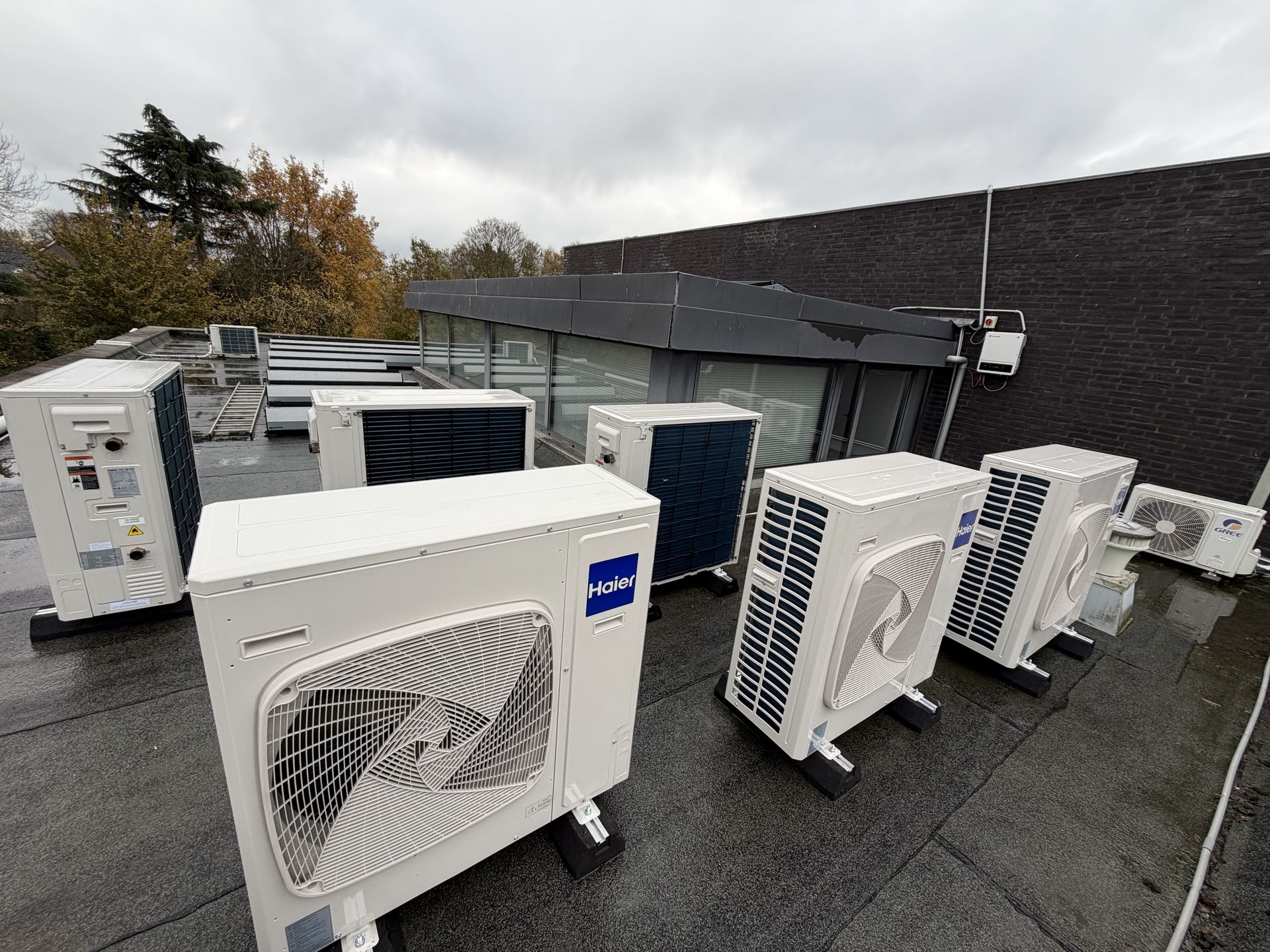Multiple Haier heat pump units outside a commercial building