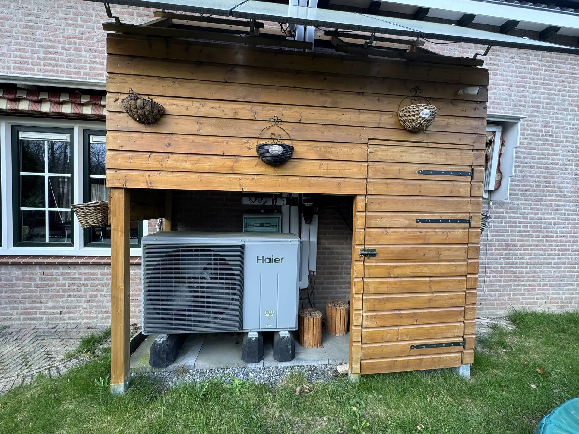 Haier heat pump installed beside a Dutch home under a covered outdoor area